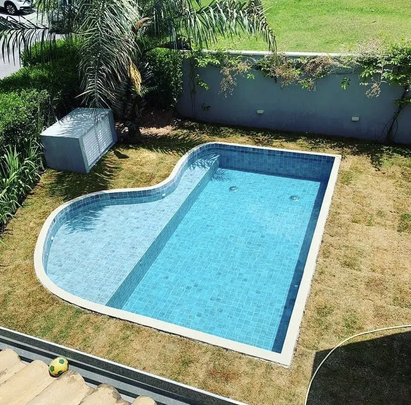 Piscina azul com prainha lateral